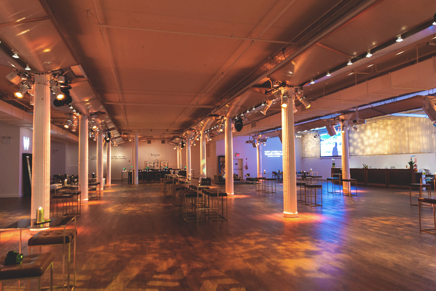 Spacious event hall with warm ambient lighting and setup for social gathering.
